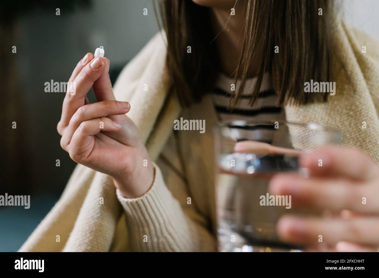 Woman taking medicine at home Stock Photo