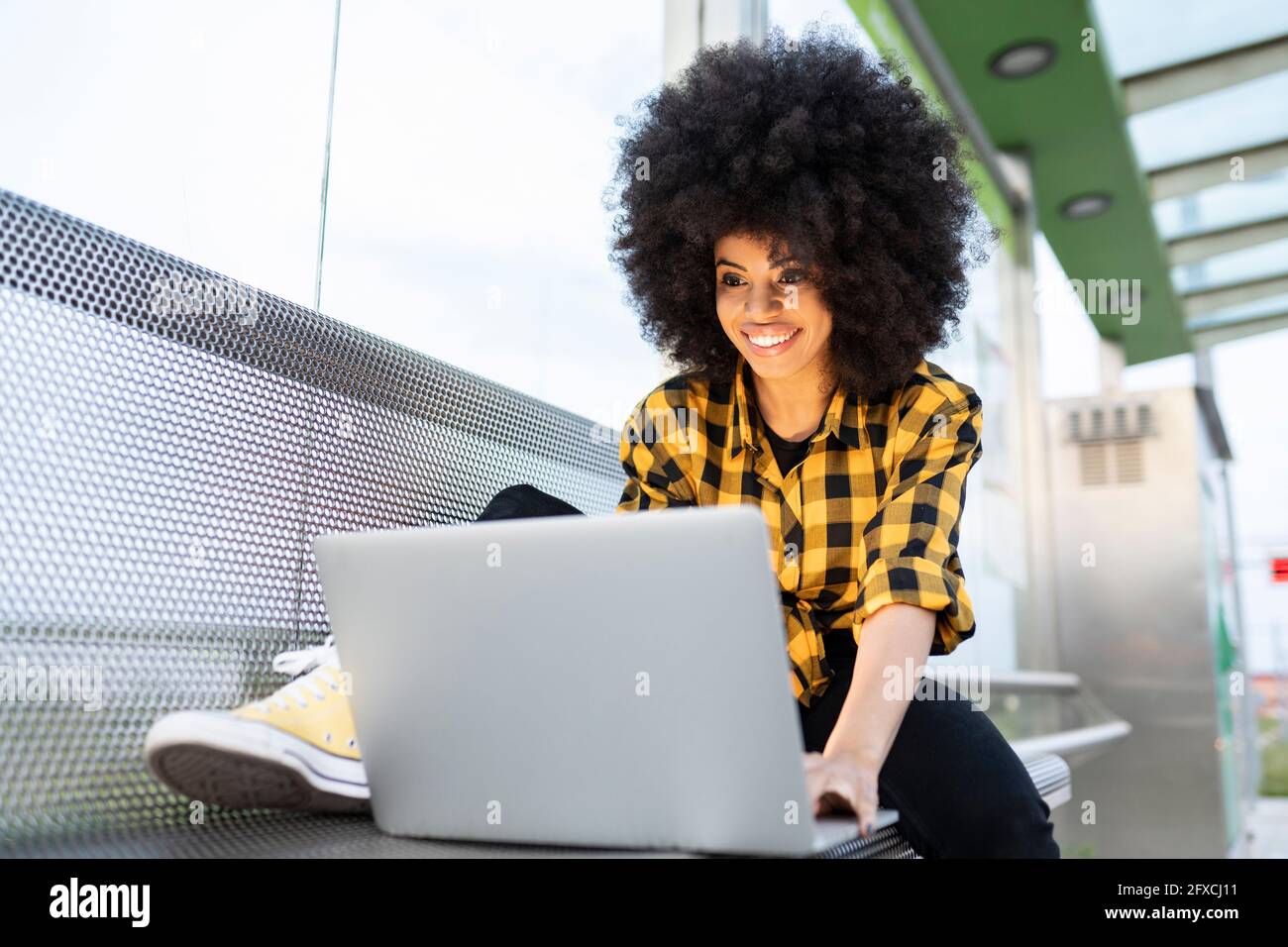 Woman using laptop on bench Stock Photo