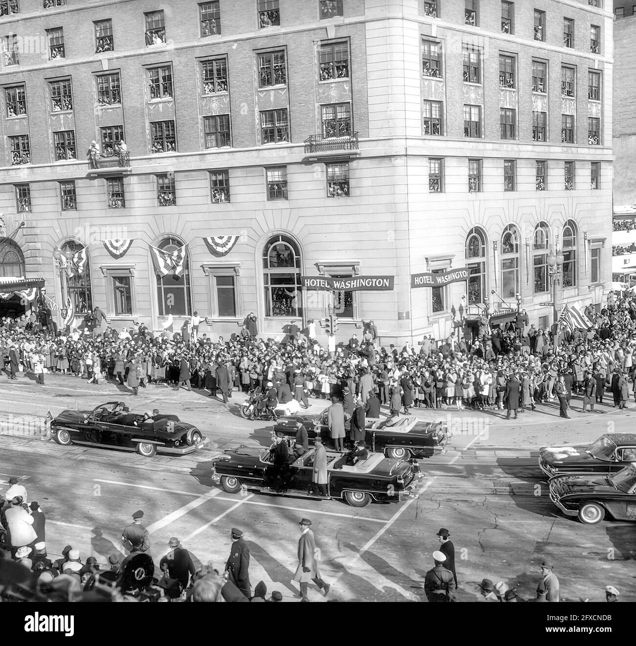 Inaugural Parade for President John F. Kennedy along Pennsylvania Avenue, Washington, D.C. The Presidential motorcade turns onto NW 15th Street from Pennsylvania Avenue in front of Hotel Washington. President Kennedy and First Lady Jacqueline Kennedy in lead car. Stock Photo