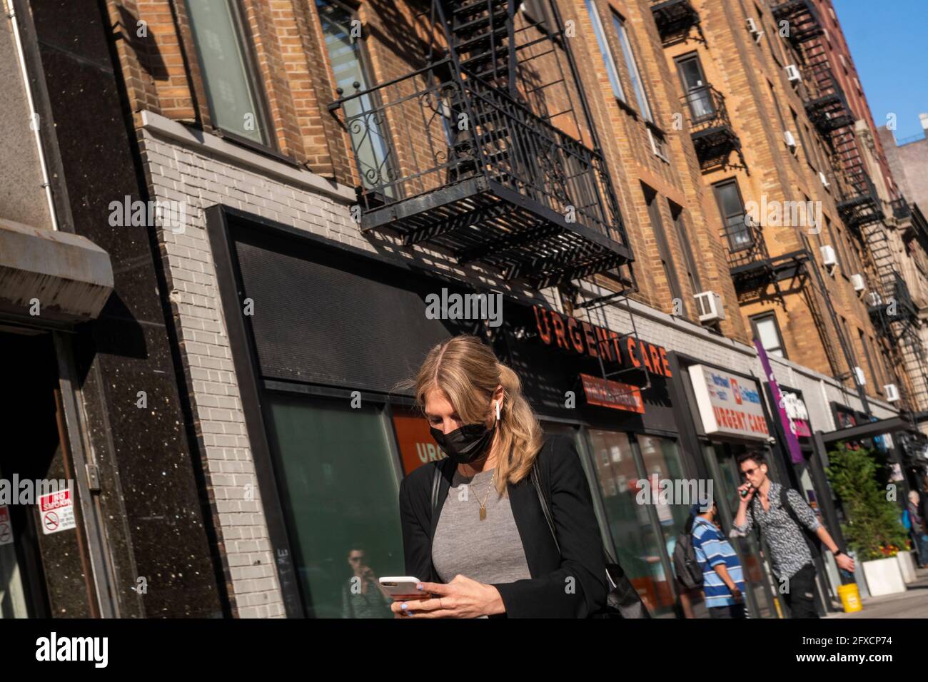 Masked and mask-less people in the Chelsea neighborhood in New York on Friday, May 21, 2021. New York has relaxed mask mandates allowing most outdoor activities to be mask free as well as many indoor settings, with caveats. (© Richard B. Levine) Stock Photo
