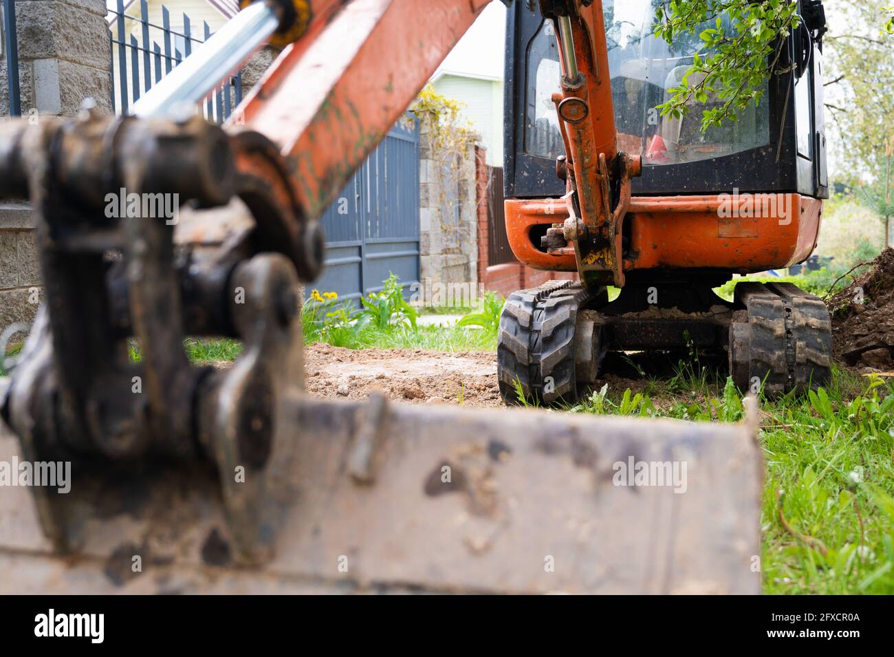 Mini excavator in orange color. construction equipment rental Stock Photo