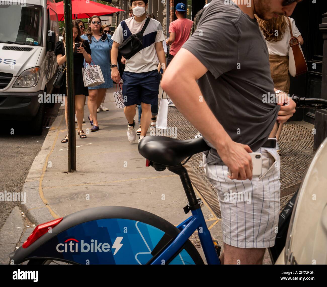 Masked and mask-less people in the Soho neighborhood in New York on Saturday, May 22, 2021. New York has relaxed mask mandates allowing most outdoor activities to be mask free as well as many indoor settings, with caveats. (© Richard B. Levine) Stock Photo