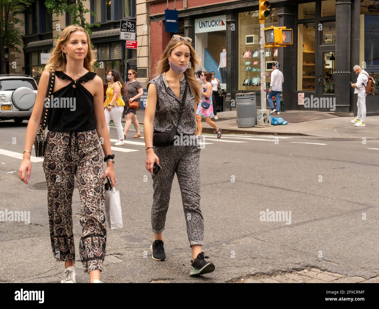 Mask-less people in the Soho neighborhood in New York on Saturday, May 22, 2021. New York has relaxed mask mandates allowing most outdoor activities to be mask free as well as many indoor settings, with caveats. (© Richard B. Levine) Stock Photo