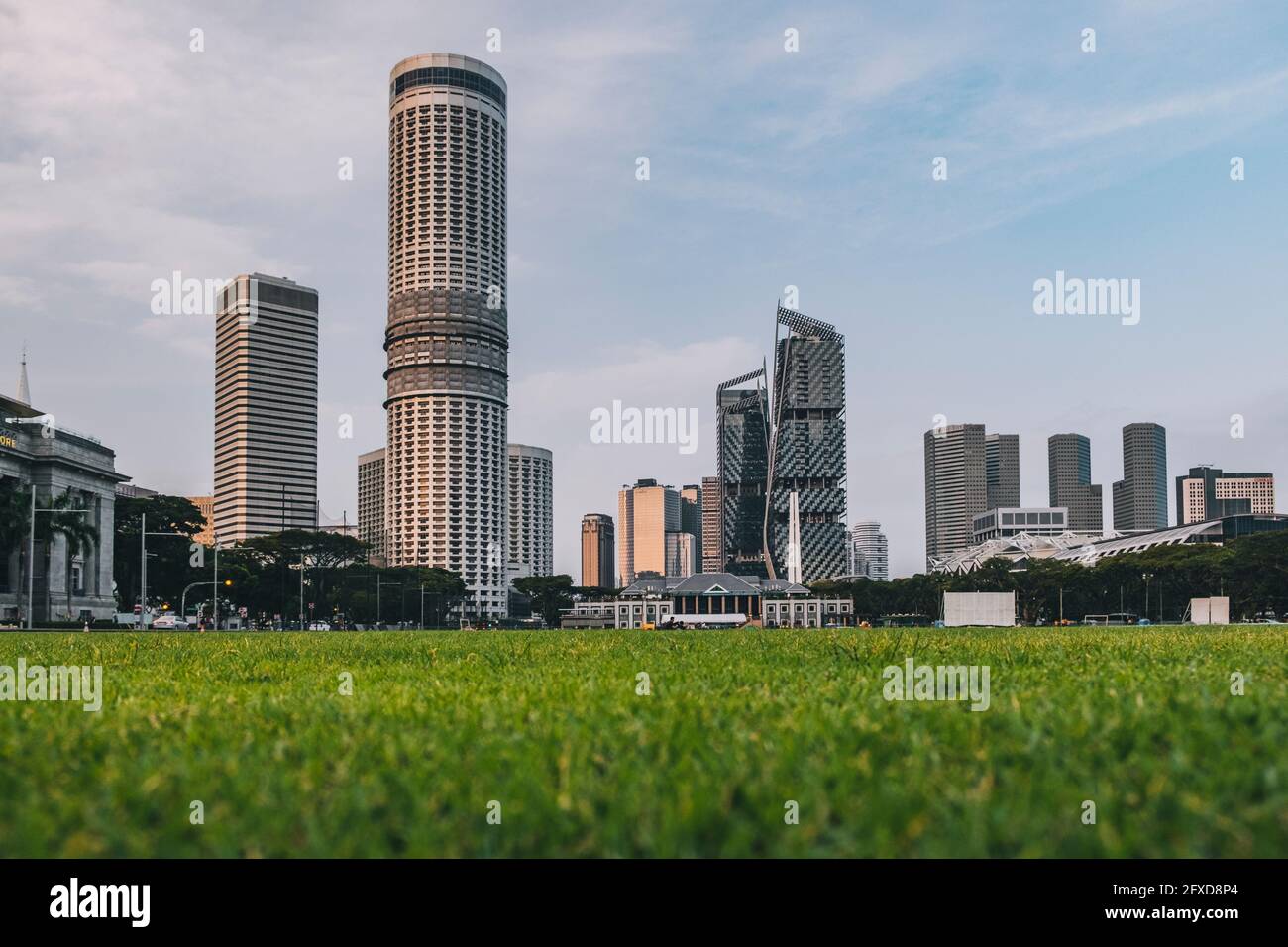 Padang playing green fields with a low angle of the city convention center and other skyscrapers, Singapore. Stock Photo