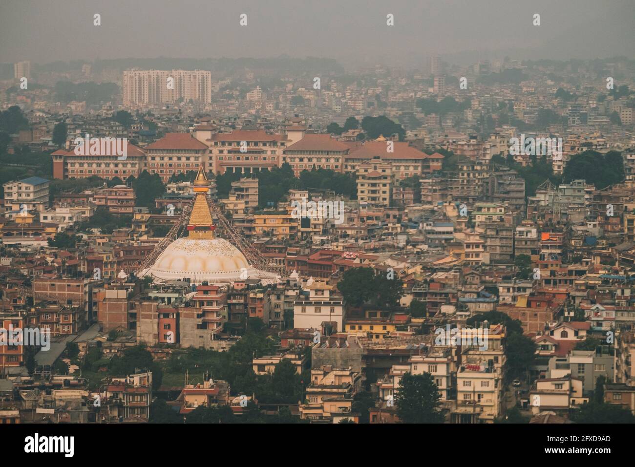 Boudha Stupa surrounded by Kathmandu's city infrastructure in a hazy day while landing in the international airport, Nepal Stock Photo