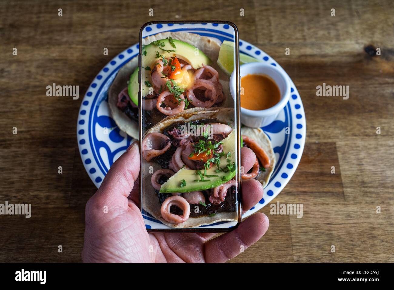 Man Taking Photos Of Mexican Food On The Table Squid Tacos Stock Photo Alamy