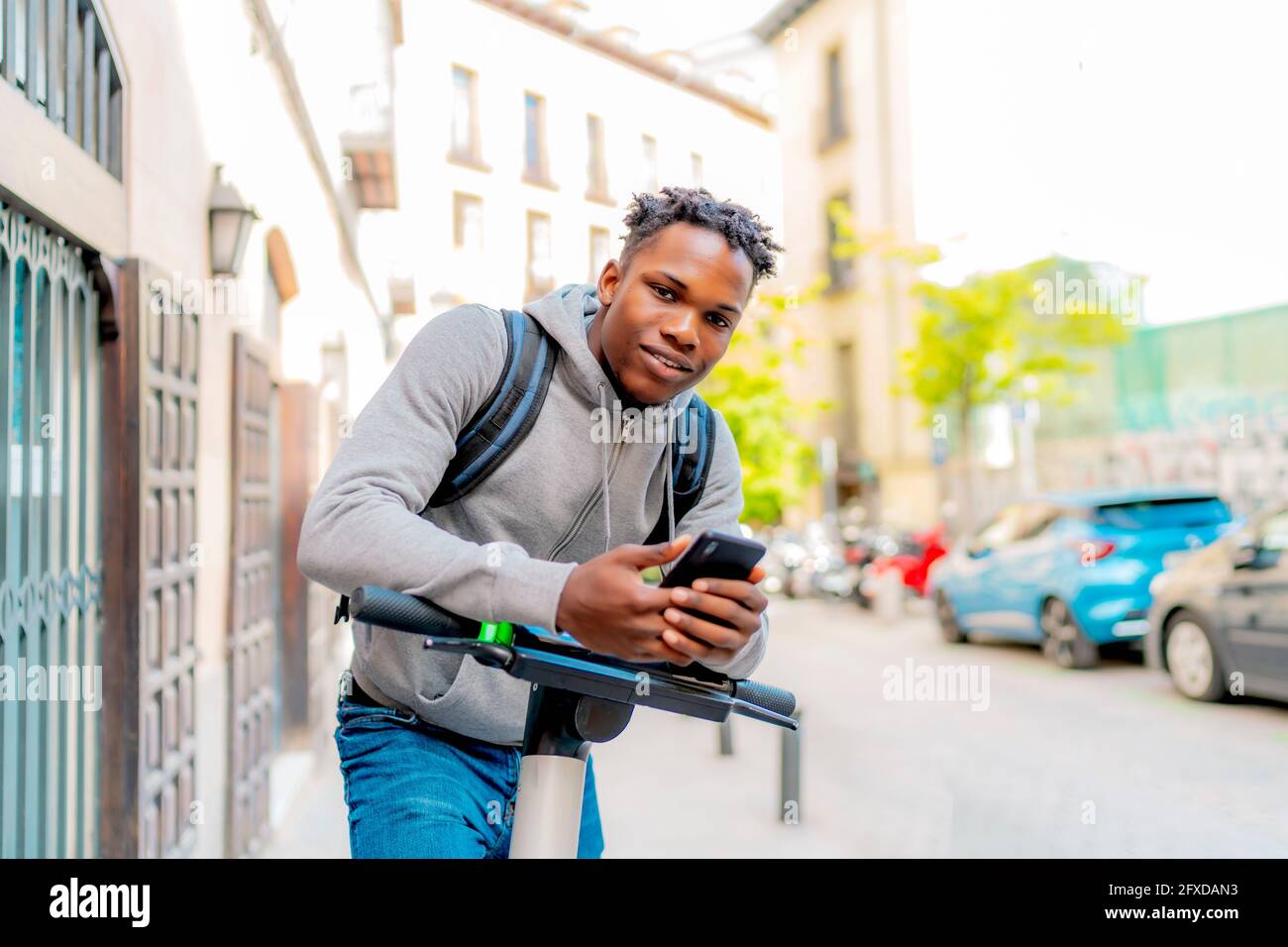 young african man renting an electric scooter Stock Photo - Alamy