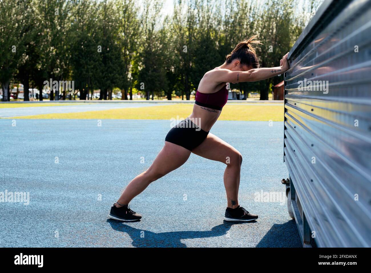 Young woman doing stretching exercises outdoors Stock Photo