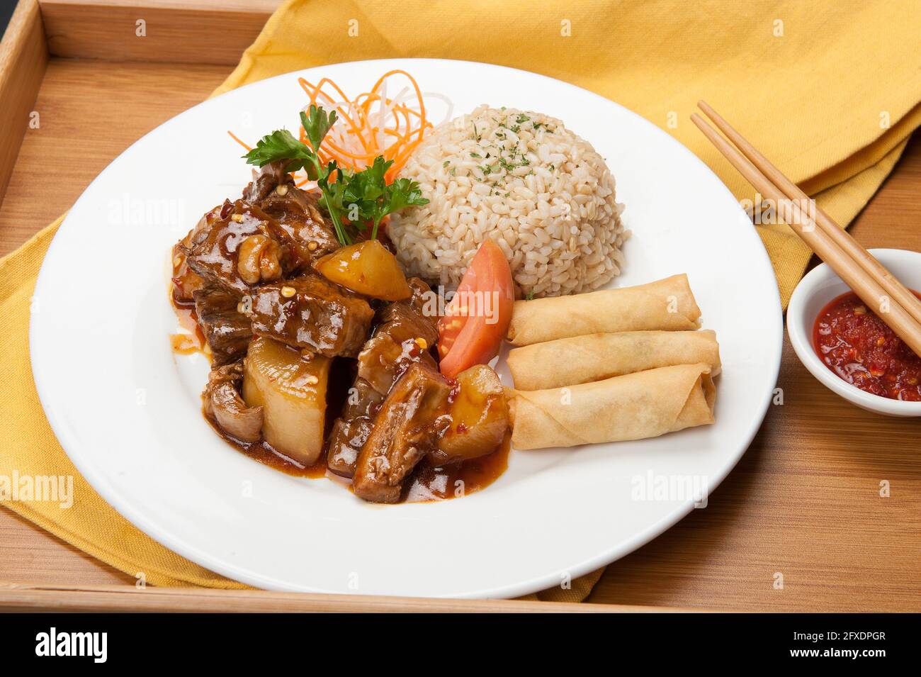 Beef ribs, spring rolls, and brown rice at a Korean restaurant. Stock Photo