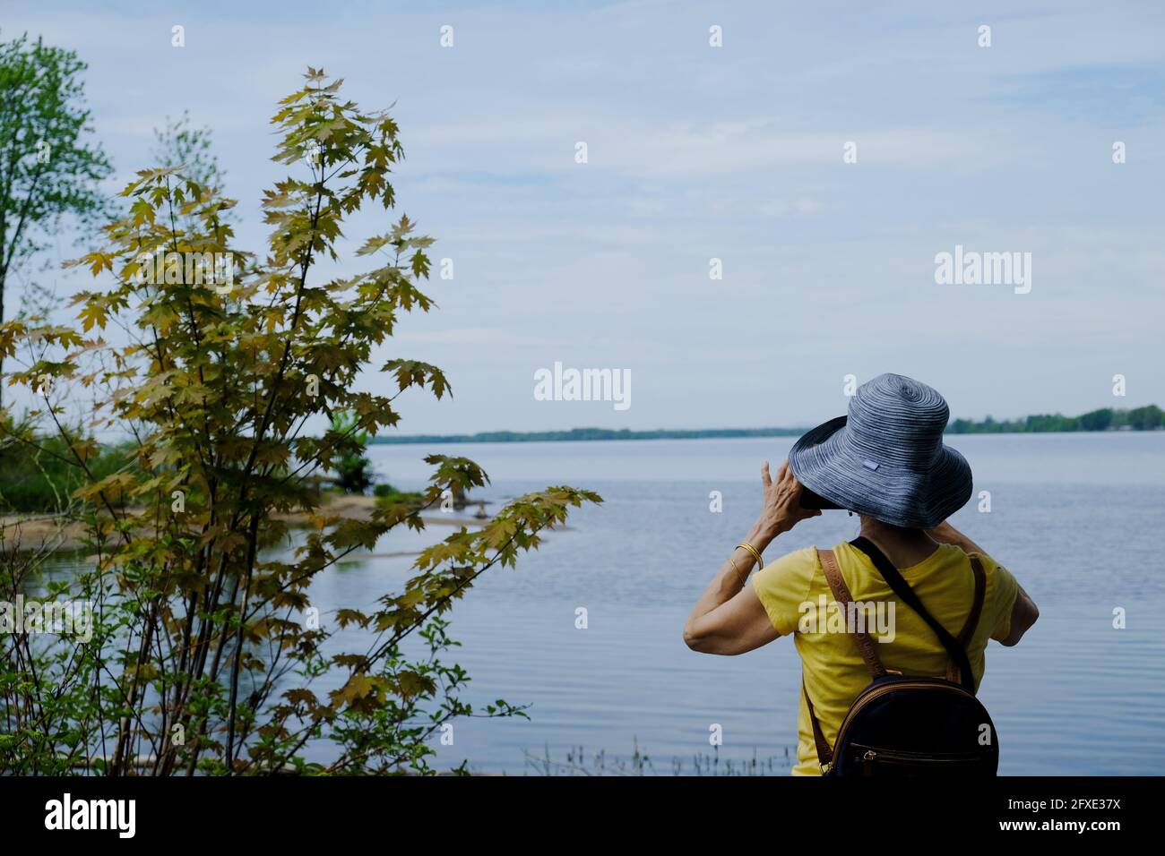 Active senior taking a photo at Petrie Island wetlands on the Ottawa