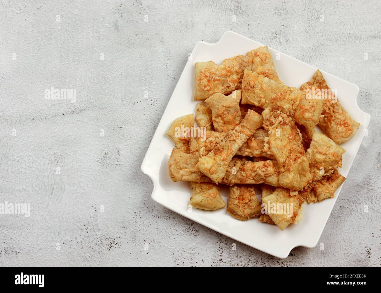 Puff pastry cheese straws on a white rectangular plate on a light gray background. Top view, flat lay Stock Photo