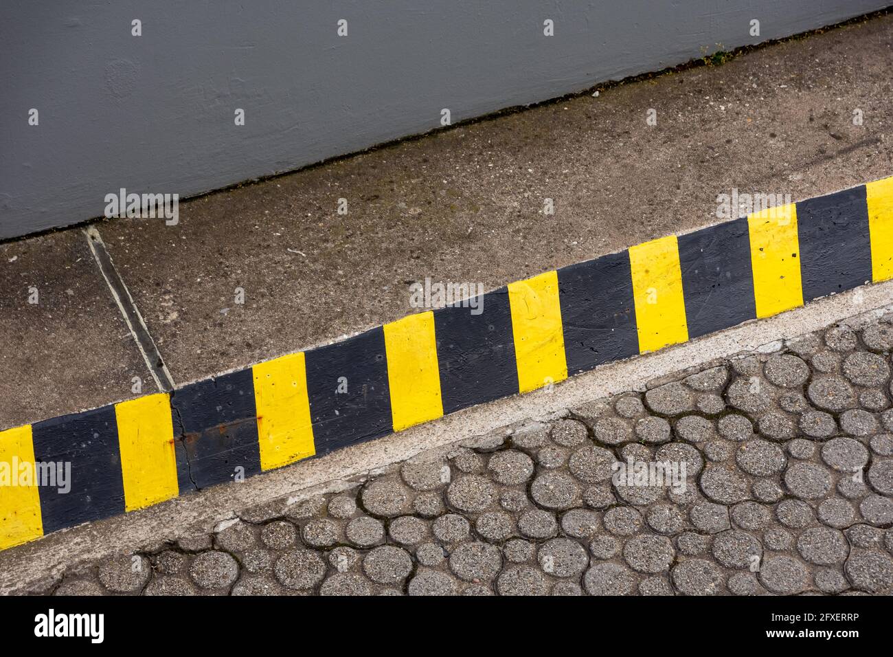 Line at the edge of a road with black and yellow streaks indicating