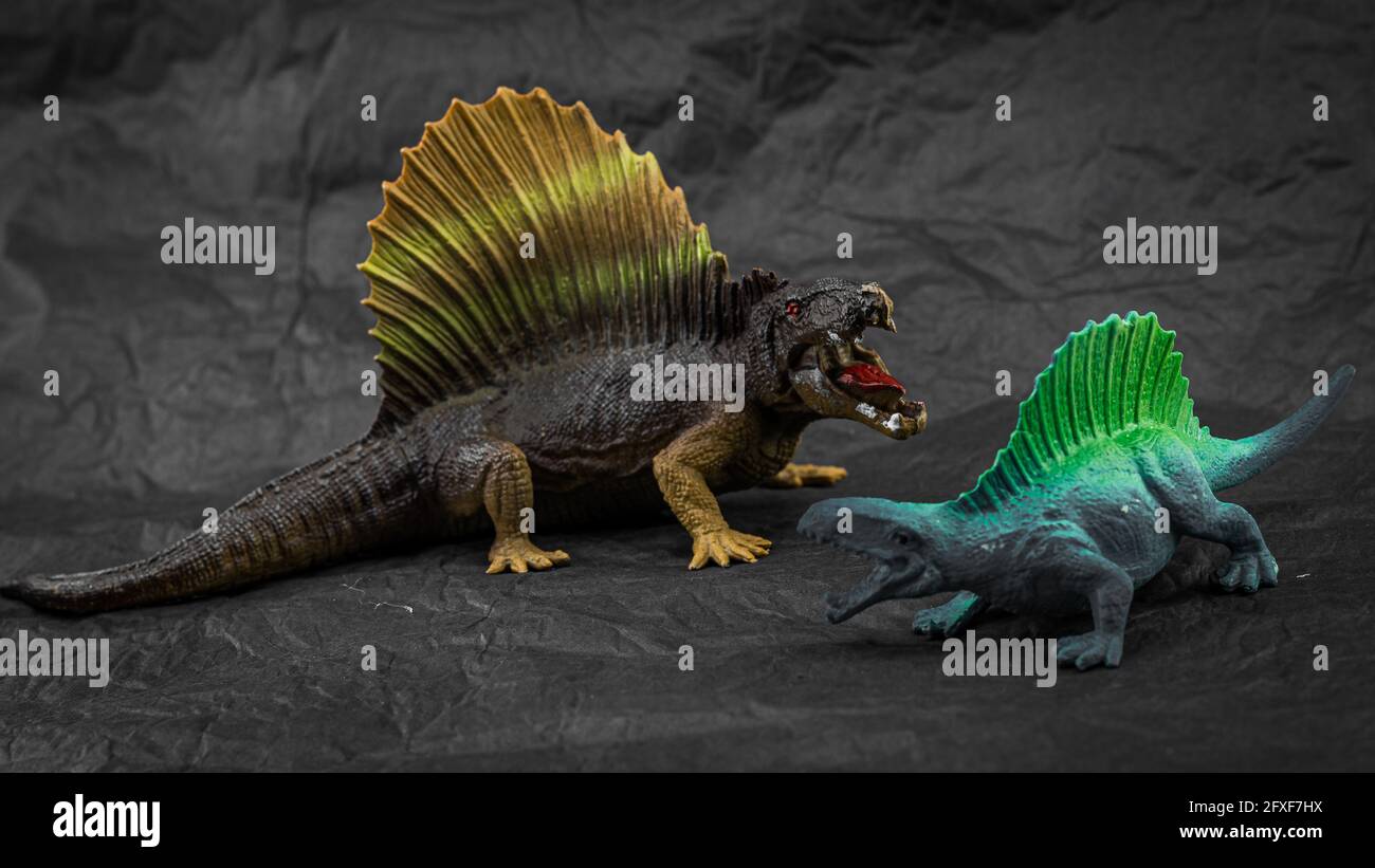 little plastic model of toy dinosaur on dark background Stock Photo