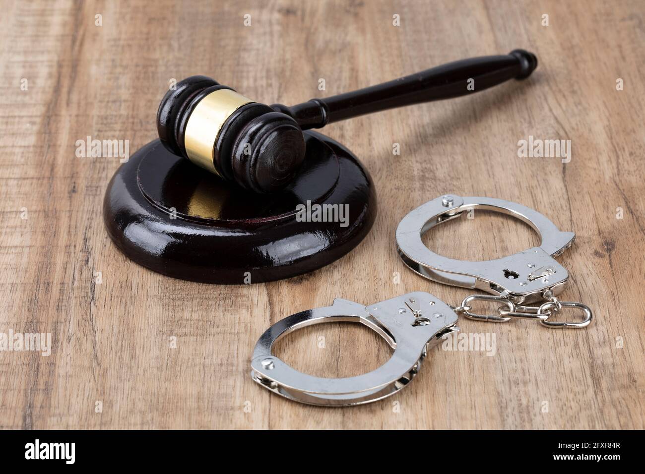 Crime and law - handcuffs and gavel Stock Photo