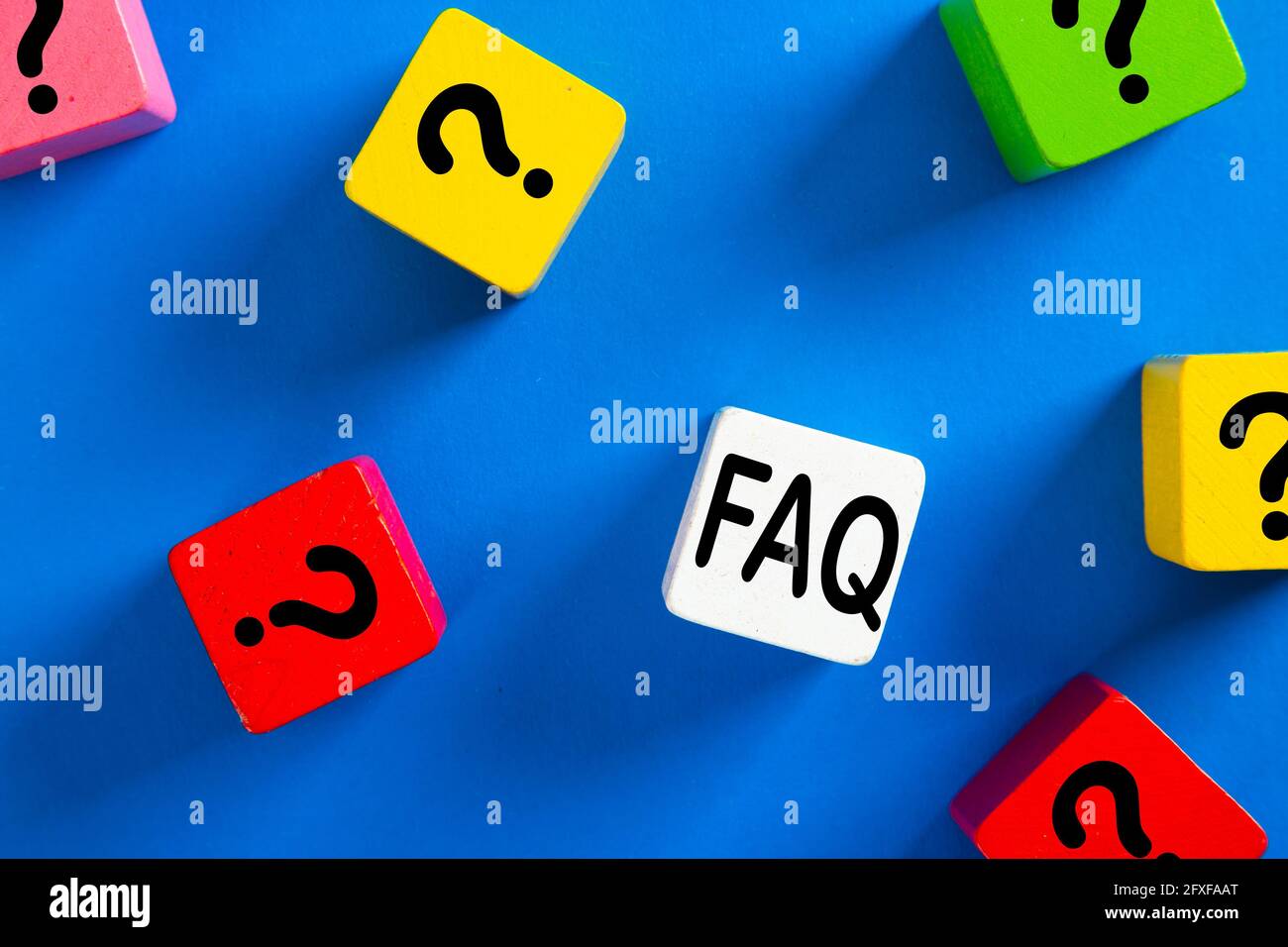 Question mark icon on blue wooden block on blue background. Q&A or FAQ ...