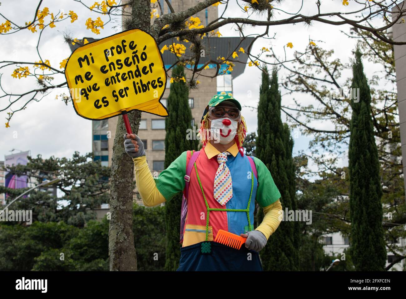 Medellin, Colombia. 26th May, 2021. A demonstrator wearing a clown costume holds a sign that reads 'My teacher teached me to understand what is to be free' in a performing arts demonstration as artists and demonstrators protested against the government of president Ivan Duque Marquez and the abuse of force by police that leads to at least 40 dead across the country since the nation wide antigovernment protests started. In Medellin, Colombia on May 26, 2021. Credit: Long Visual Press/Alamy Live News Stock Photo