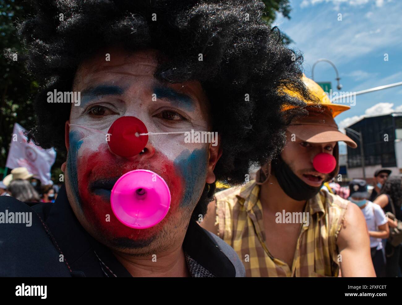 Medellin, Colombia. 26th May, 2021. Two demonstrators wear clown makeup and red noses in a performing arts demonstration as artists and demonstrators protested against the government of president Ivan Duque Marquez and the abuse of force by police that leads to at least 40 dead across the country since the nation wide antigovernment protests started. In Medellin, Colombia on May 26, 2021. Credit: Long Visual Press/Alamy Live News Stock Photo
