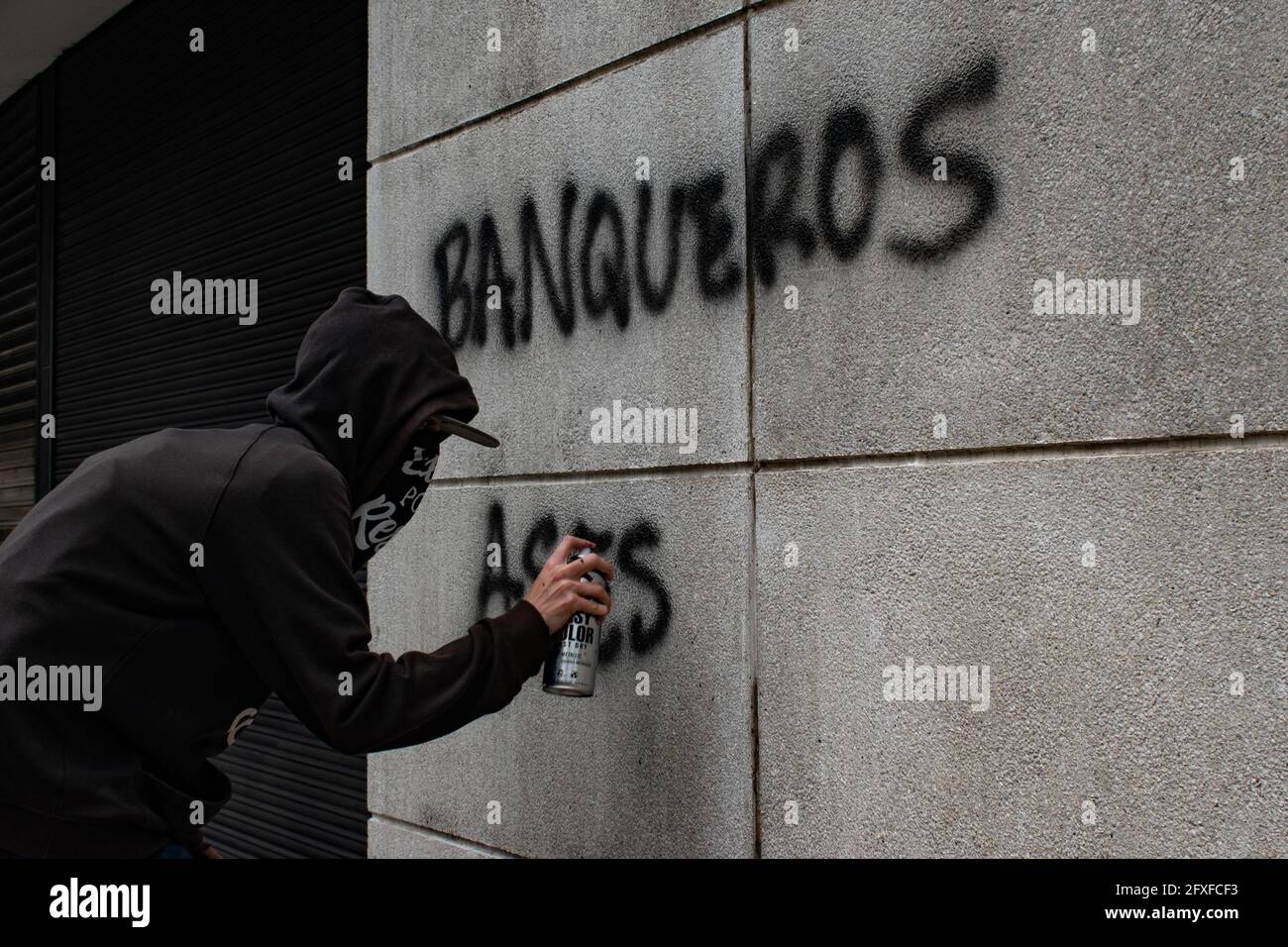 Medellin, Colombia. 26th May, 2021. A demonstrator spray paints the wall of a bank with the message 'Bankers are killers' in a performing arts demonstration as artists and demonstrators protested against the government of president Ivan Duque Marquez and the abuse of force by police that leads to at least 40 dead across the country since the nation wide antigovernment protests started. In Medellin, Colombia on May 26, 2021. Credit: Long Visual Press/Alamy Live News Stock Photo
