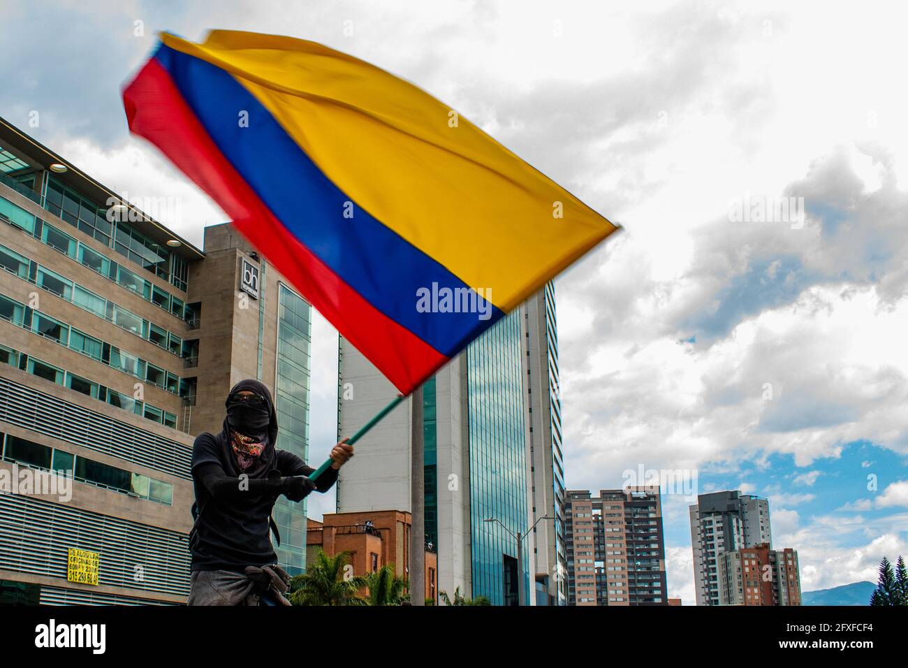 Medellin, Colombia. 26th May, 2021. A demonstrator using a hoodie to protect its identity waves a Colombian flag in a performing arts demonstration as artists and demonstrators protested against the government of president Ivan Duque Marquez and the abuse of force by police that leads to at least 40 dead across the country since the nation wide antigovernment protests started. In Medellin, Colombia on May 26, 2021. Credit: Long Visual Press/Alamy Live News Stock Photo