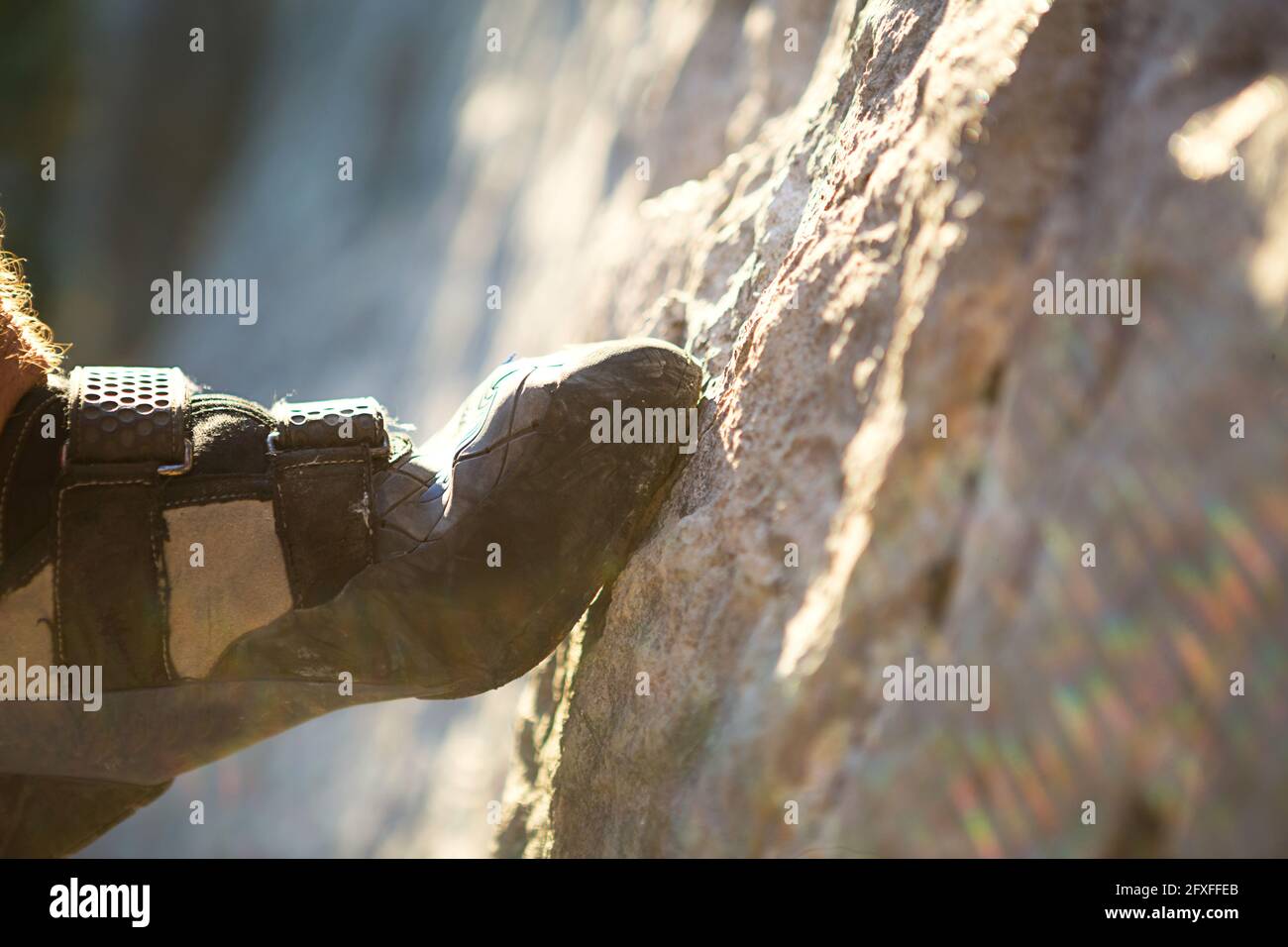 Climbing shoes on the climber's foot rest the toe on the rock. Extreme
