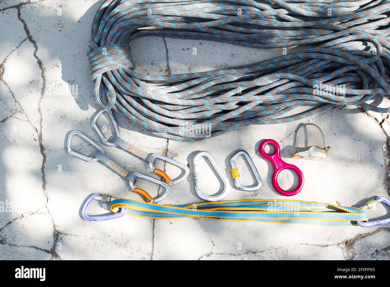 Coiled climbing rope and steel carabiner. Mountain climbing equipment