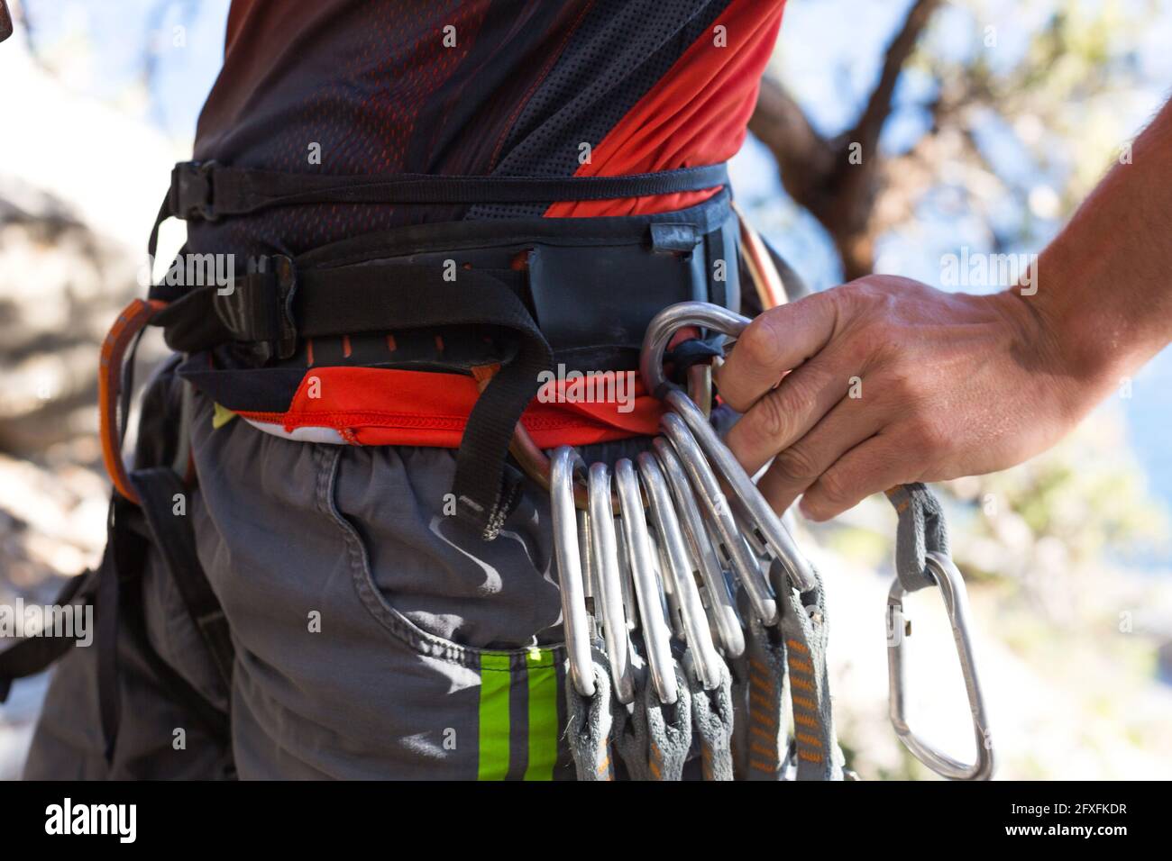 Climbing equipment on a male climber rock shoes, rope, quickdraw