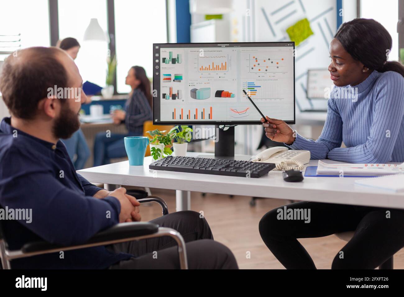 Diverse team working together with financial graphs discussing solution ...