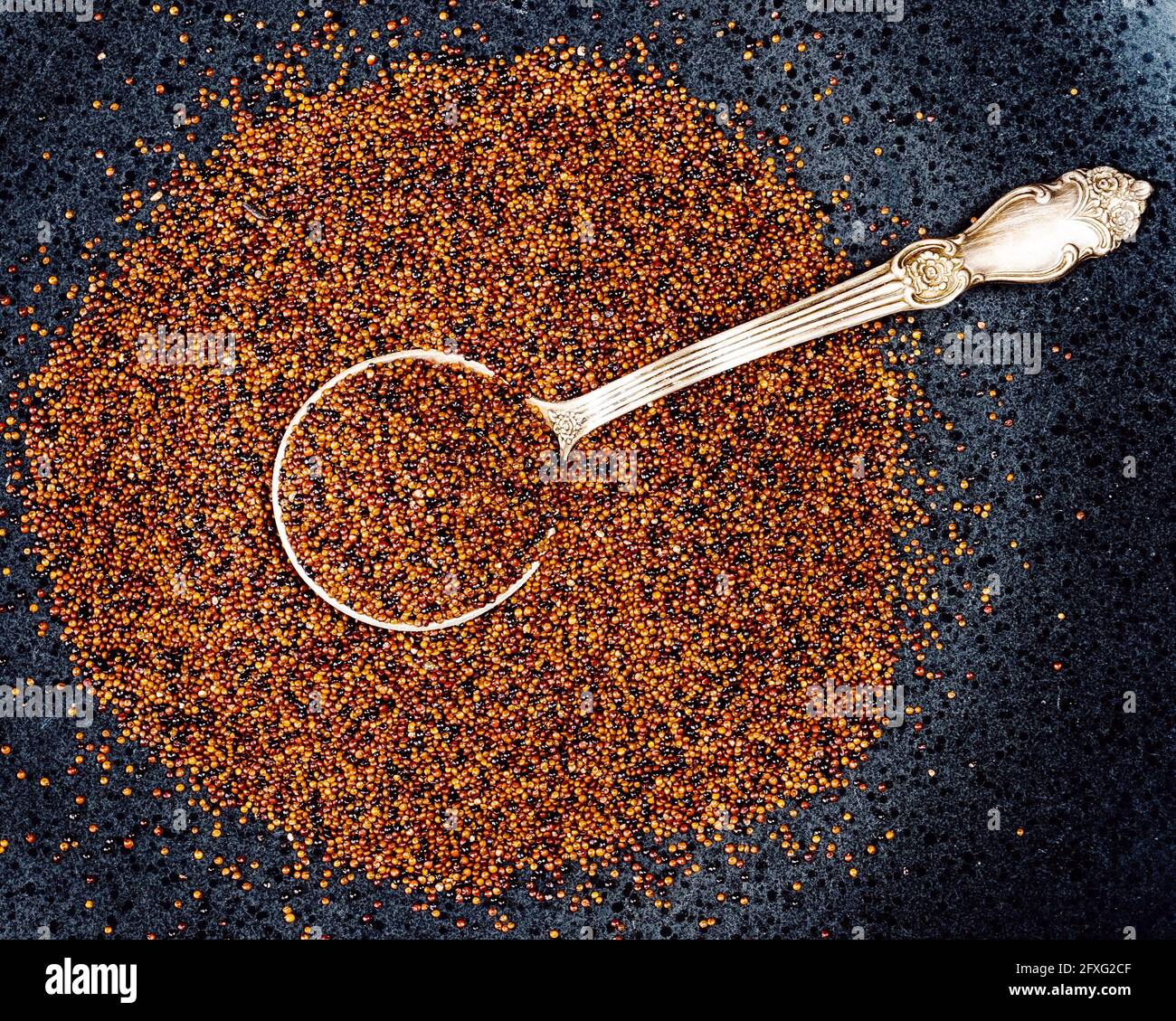 top view of tablespoon in canihua seeds on black plate Stock Photo