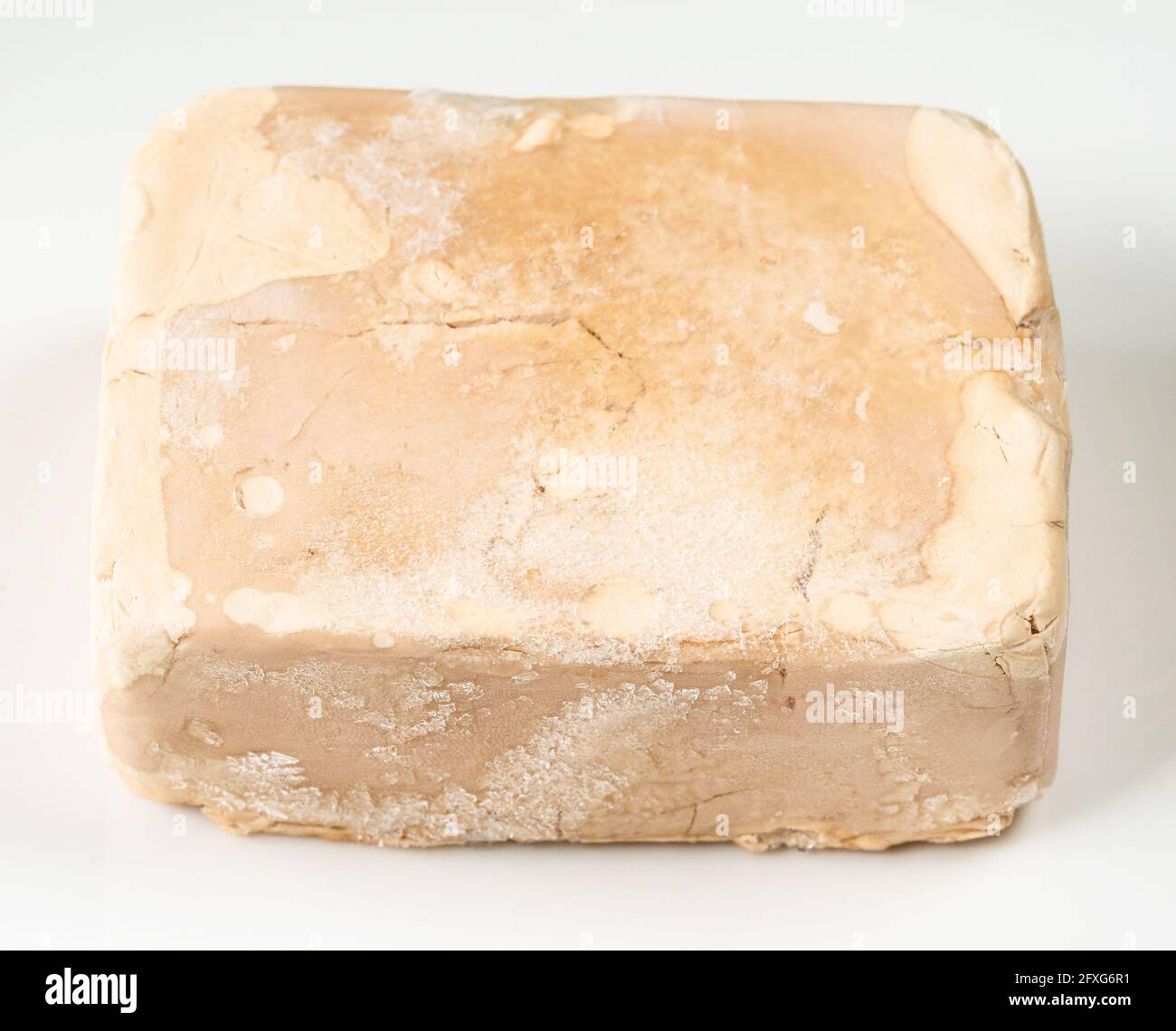 frozen fresh compressed yeast cake on white plate closeup Stock Photo
