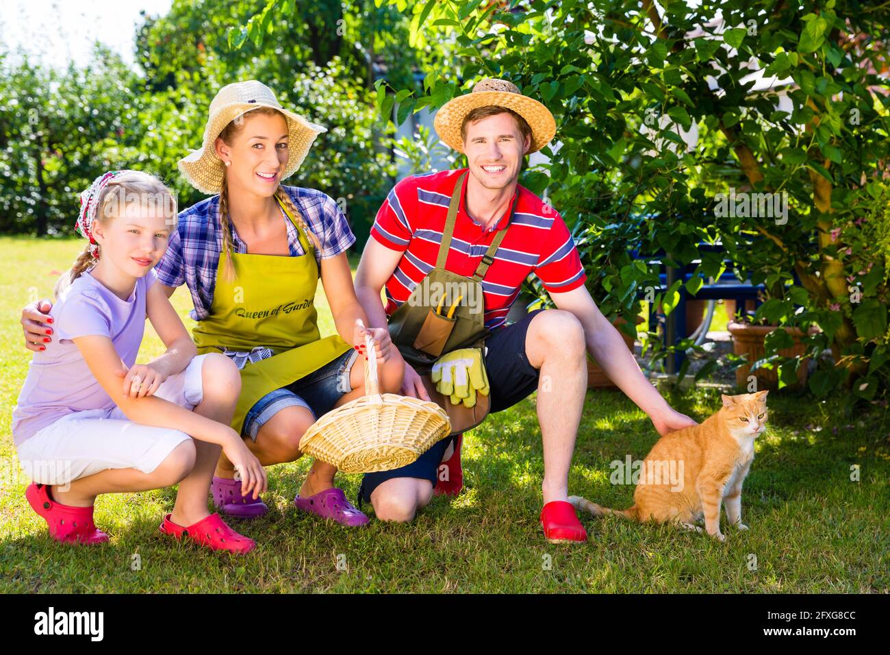 Family with cat gardening in garden Stock Photo - Alamy