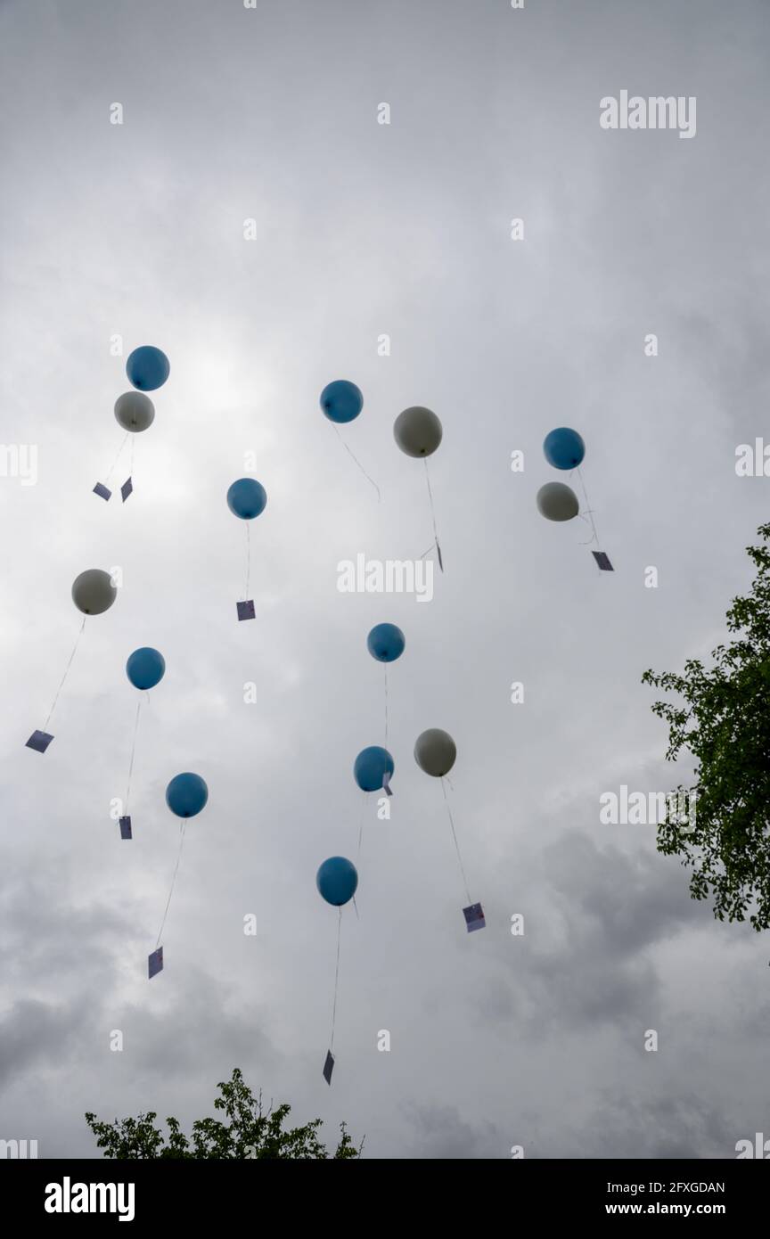 balloons flying into clouded sky at wedding Stock Photo