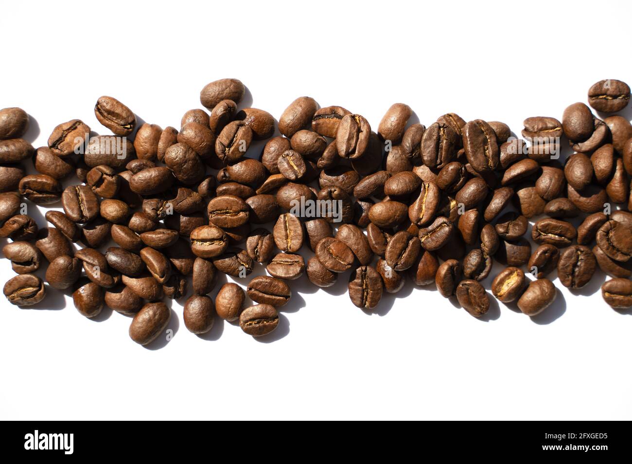 Isolated roasted coffee beans in harsh light. White background, top ...