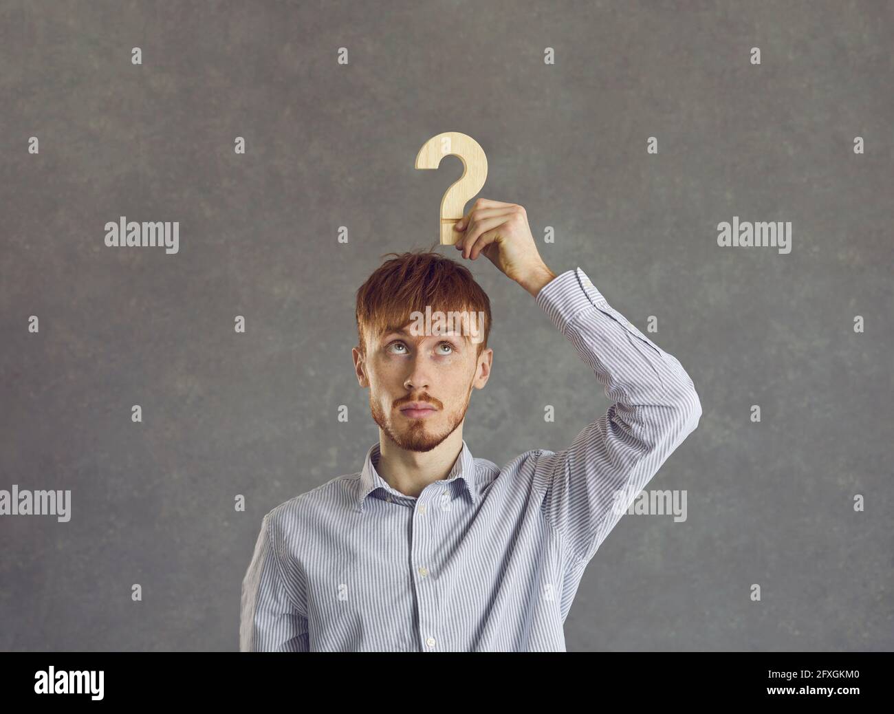 Puzzled young beginner businessman is looking for answers about the development of his business. Stock Photo