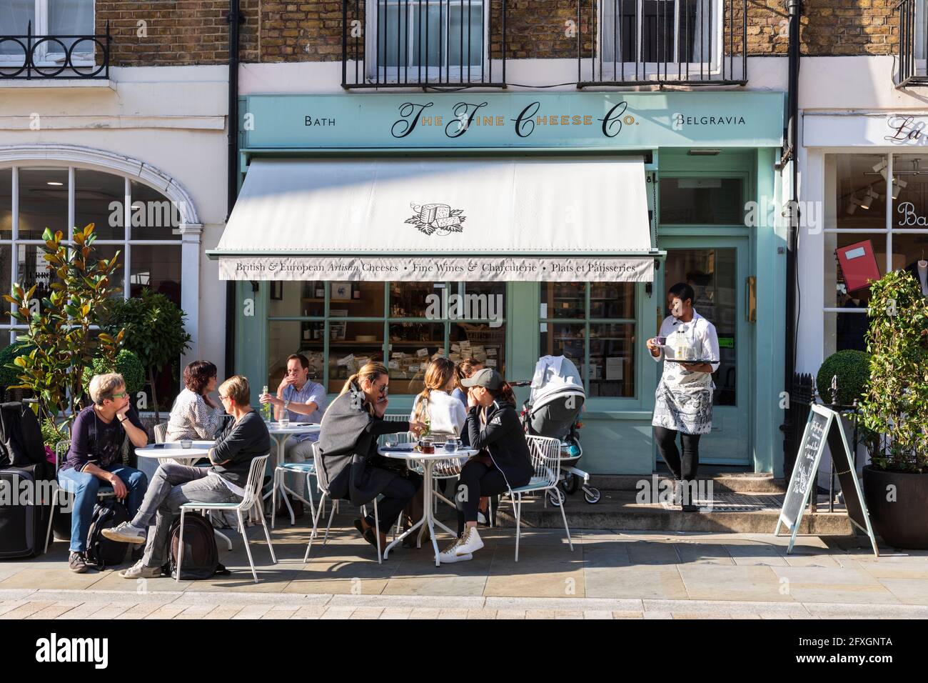 People dining outside The Fine Cheese Co. in Motcomb Street, Belgravia, London, UK. Stock Photo