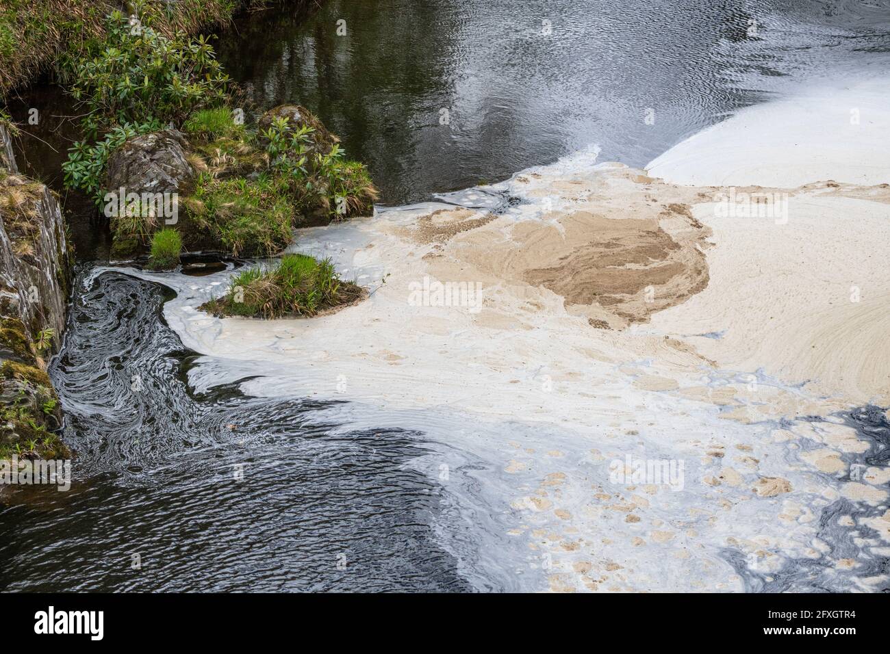 Water pollution in a river flowing from an old disused lead mine in Wales after passing through a water treatment plant Stock Photo