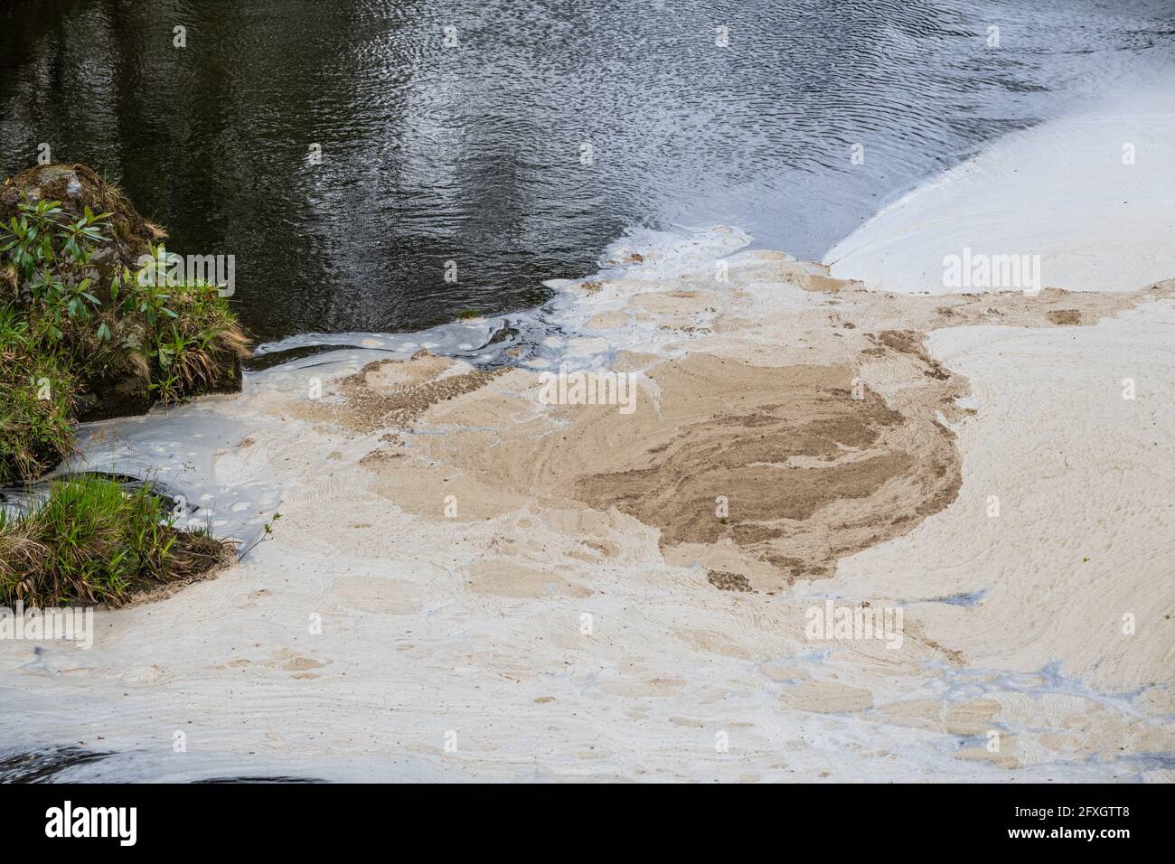 Water pollution in a river flowing from an old disused lead mine in Wales after passing through