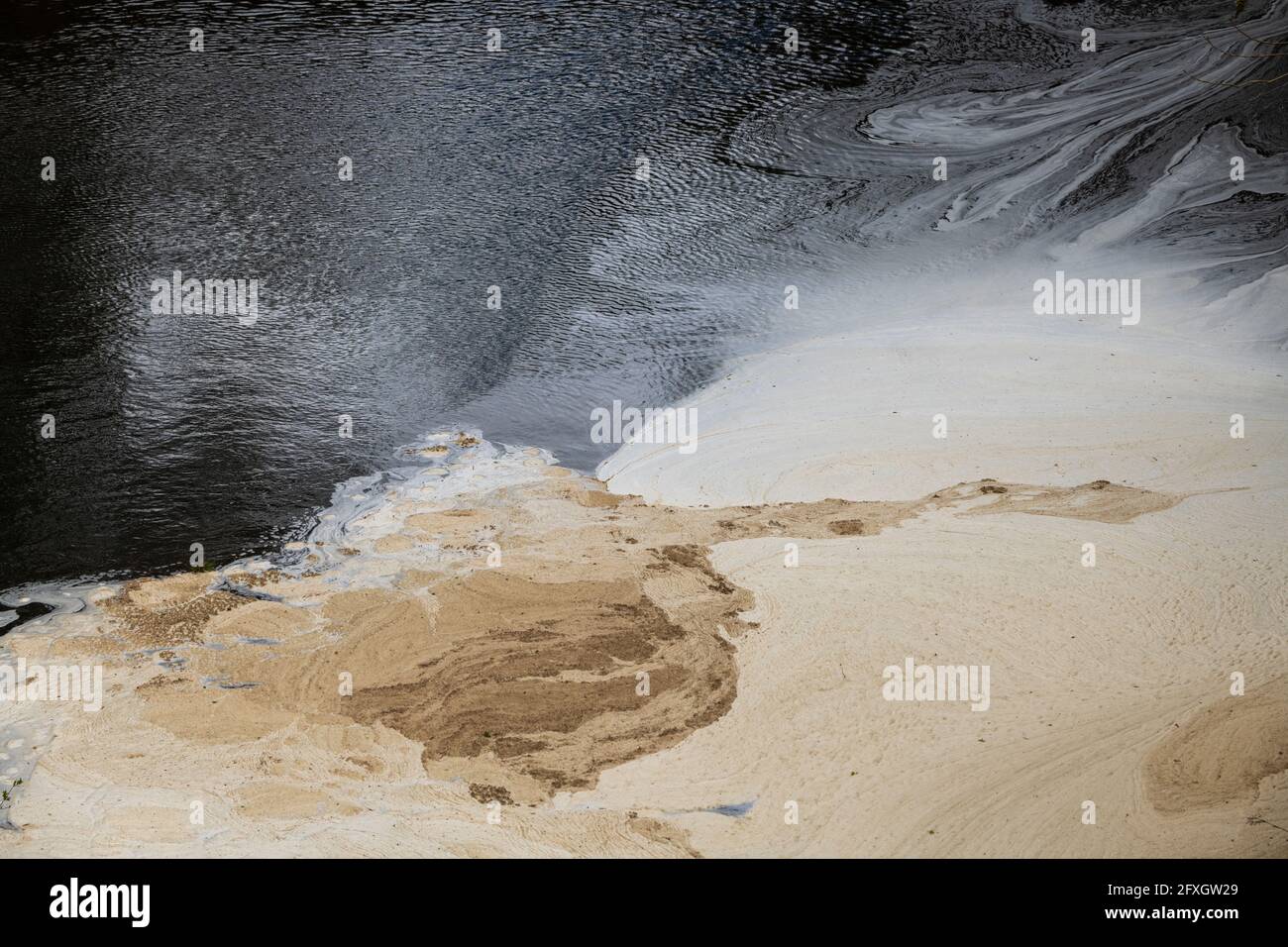 Water pollution in a river flowing from an old disused lead mine in Wales after passing through