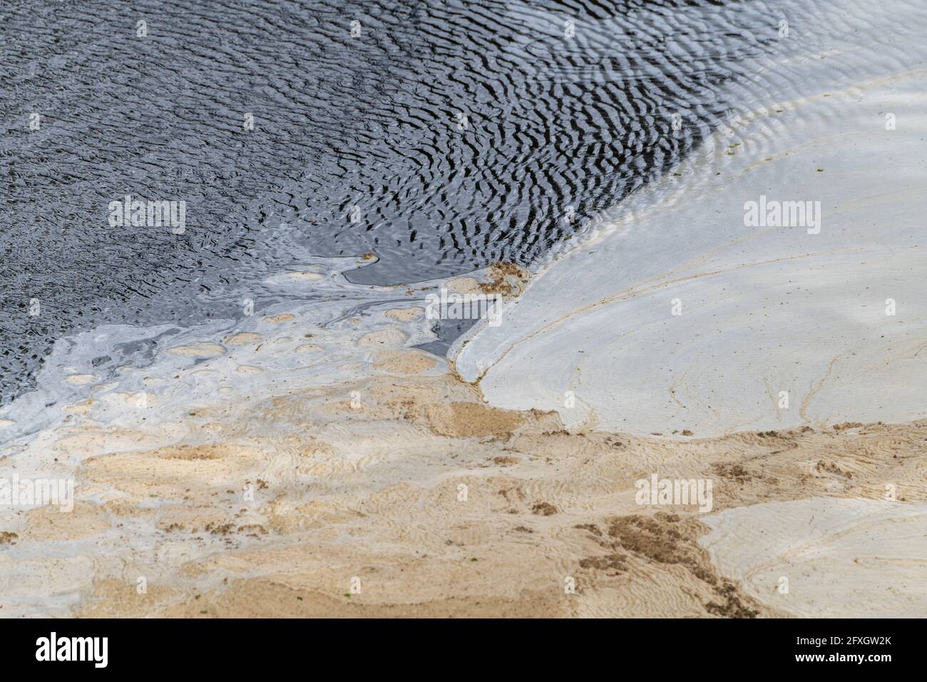 Water pollution in a river flowing from an old disused lead mine in Wales after passing through