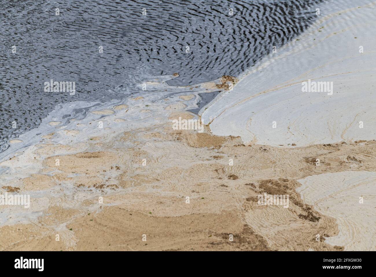 Water pollution in a river flowing from an old disused lead mine in Wales after passing through