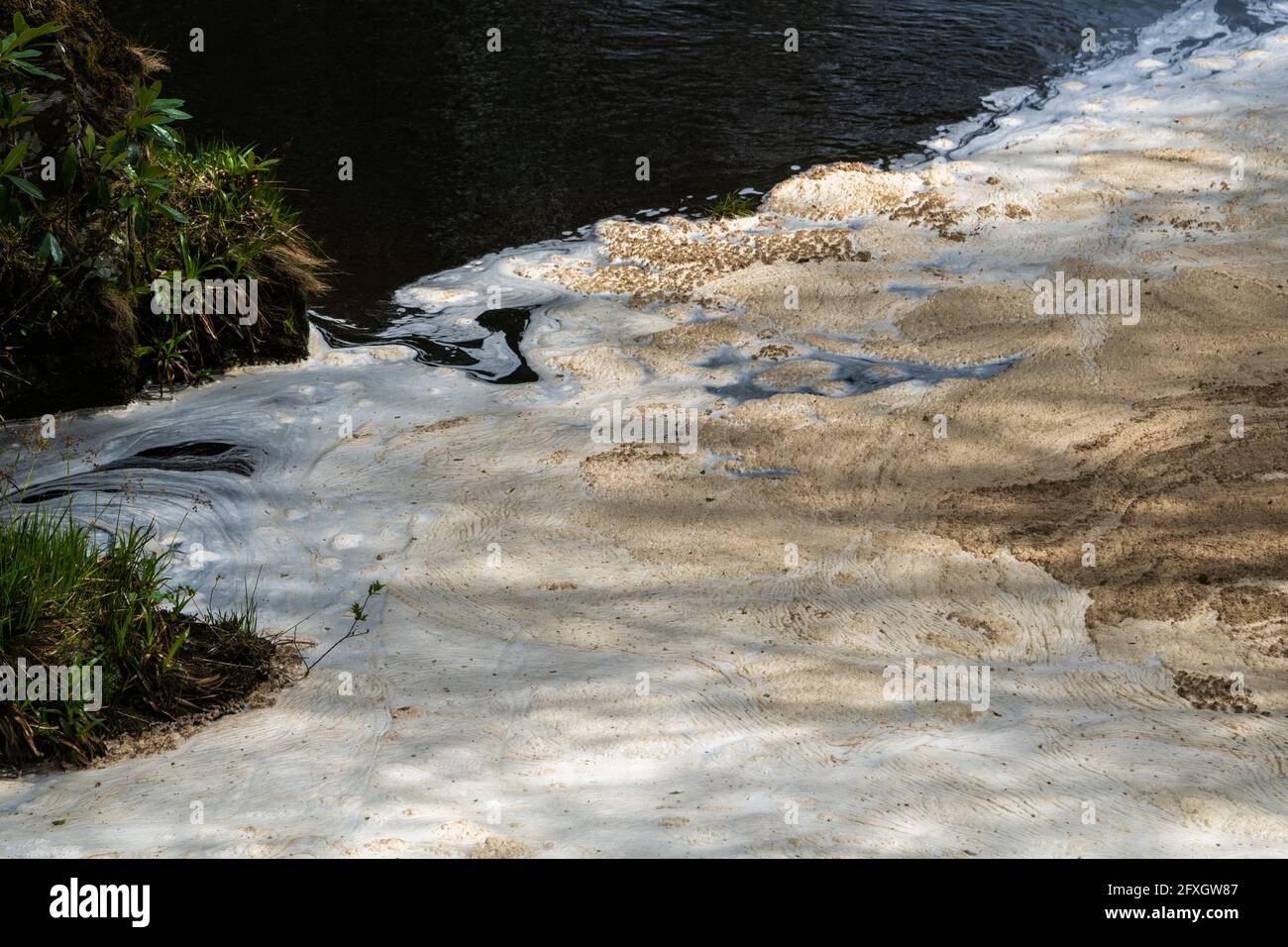 Water pollution in a river flowing from an old disused lead mine in Wales after passing through a water treatment plant Stock Photo
