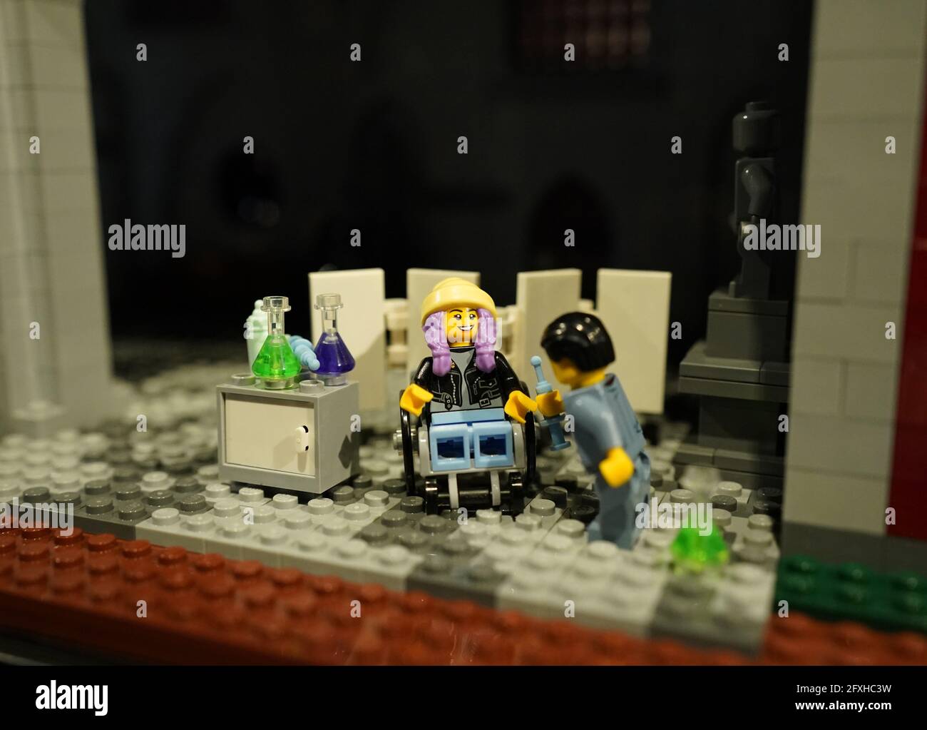 25 May 2021, Schleswig-Holstein, Lübeck: The Lego figure Juna (l) is  inoculated in the diorama "The Plague in Lübeck 1367". The girl Juna is  supposed to playfully point out current and environmental