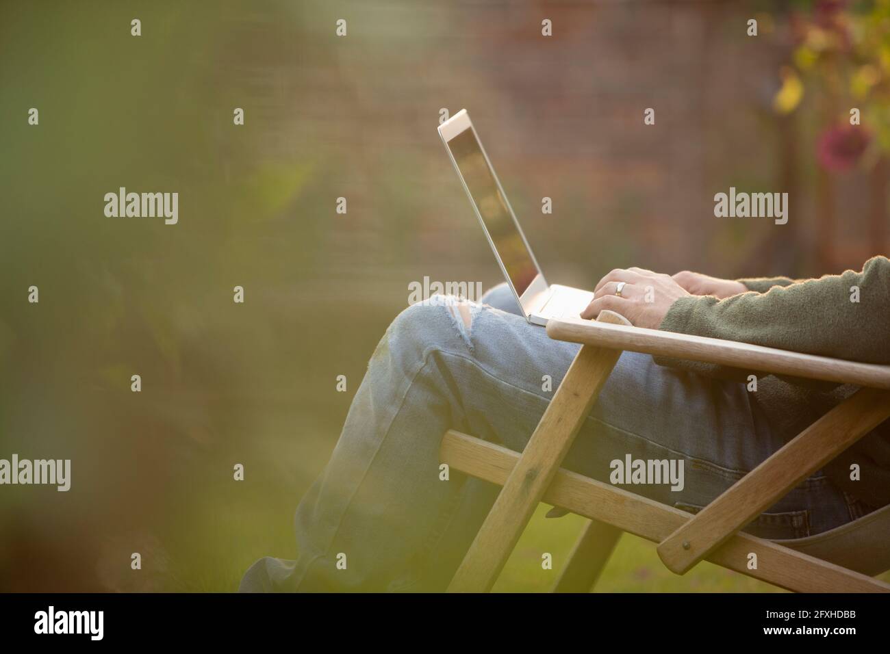 Man using laptop in garden Stock Photo