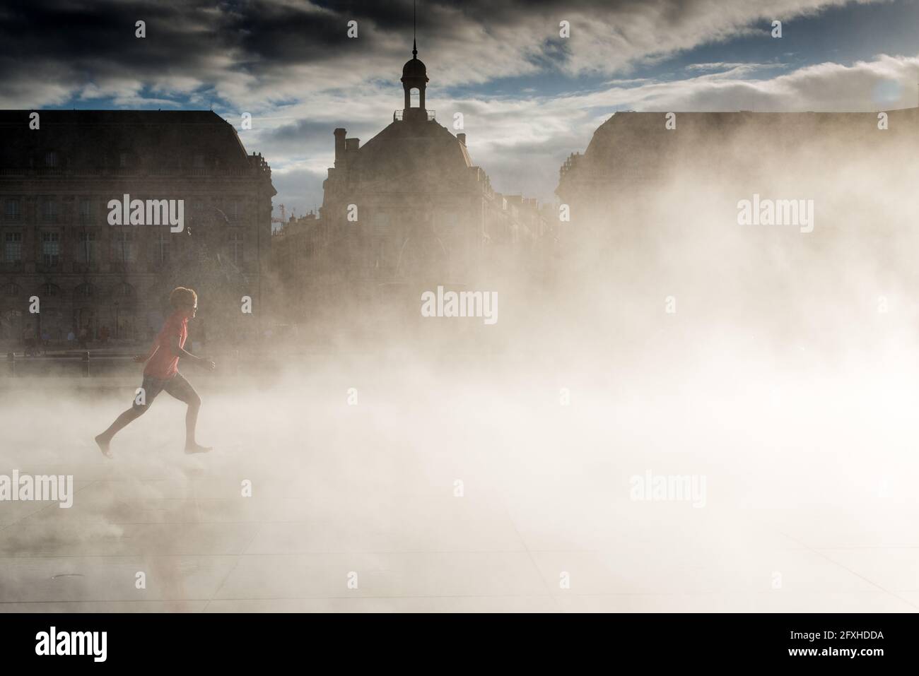FRANCE. GIRONDE (33), BORDEAUX, CHILD RUNNING TOWARDS THE MIST OF THE WATER MIRROR Stock Photo