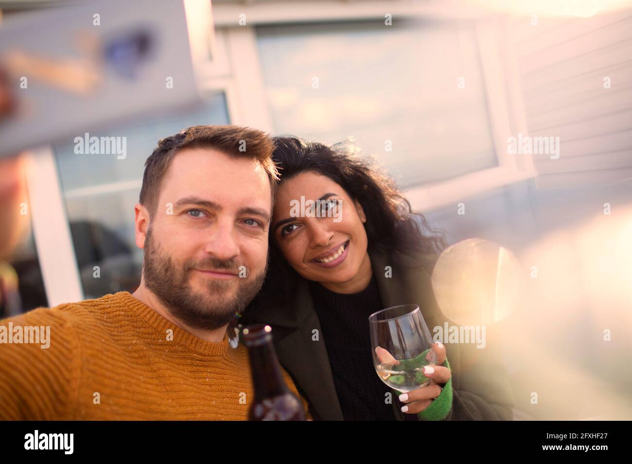 Happy couple taking selfie on patio Stock Photo
