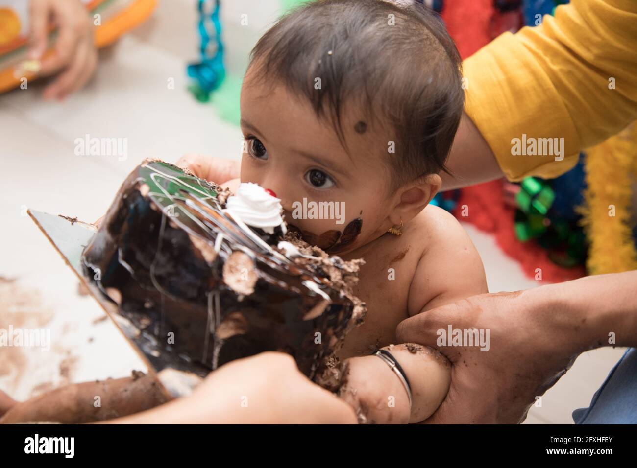 Cute Indian baby girl eating chocolate cake Stock Photo