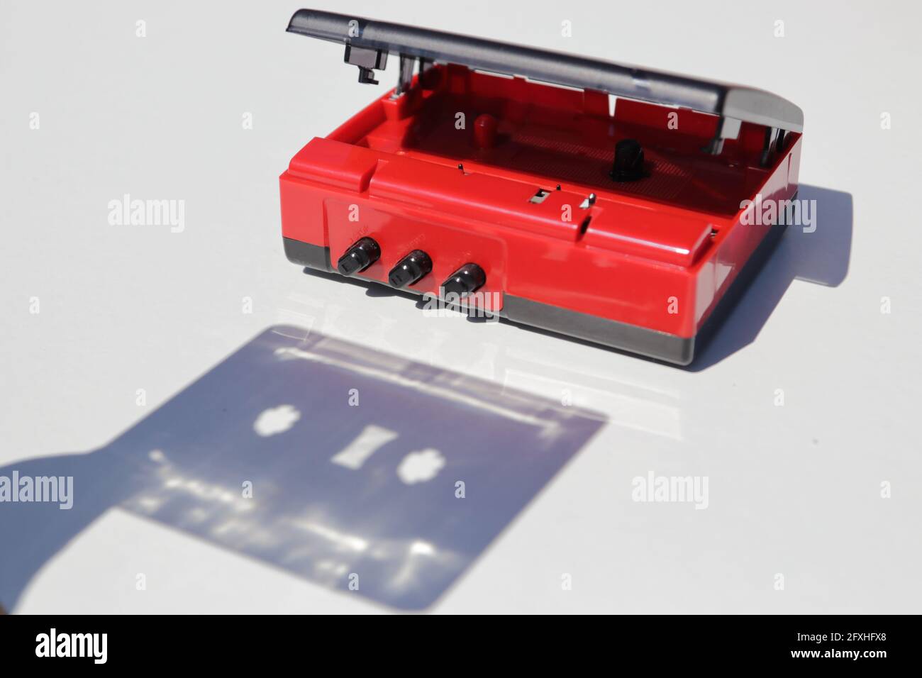 Shadow of cassette tape being inserted into a player Stock Photo