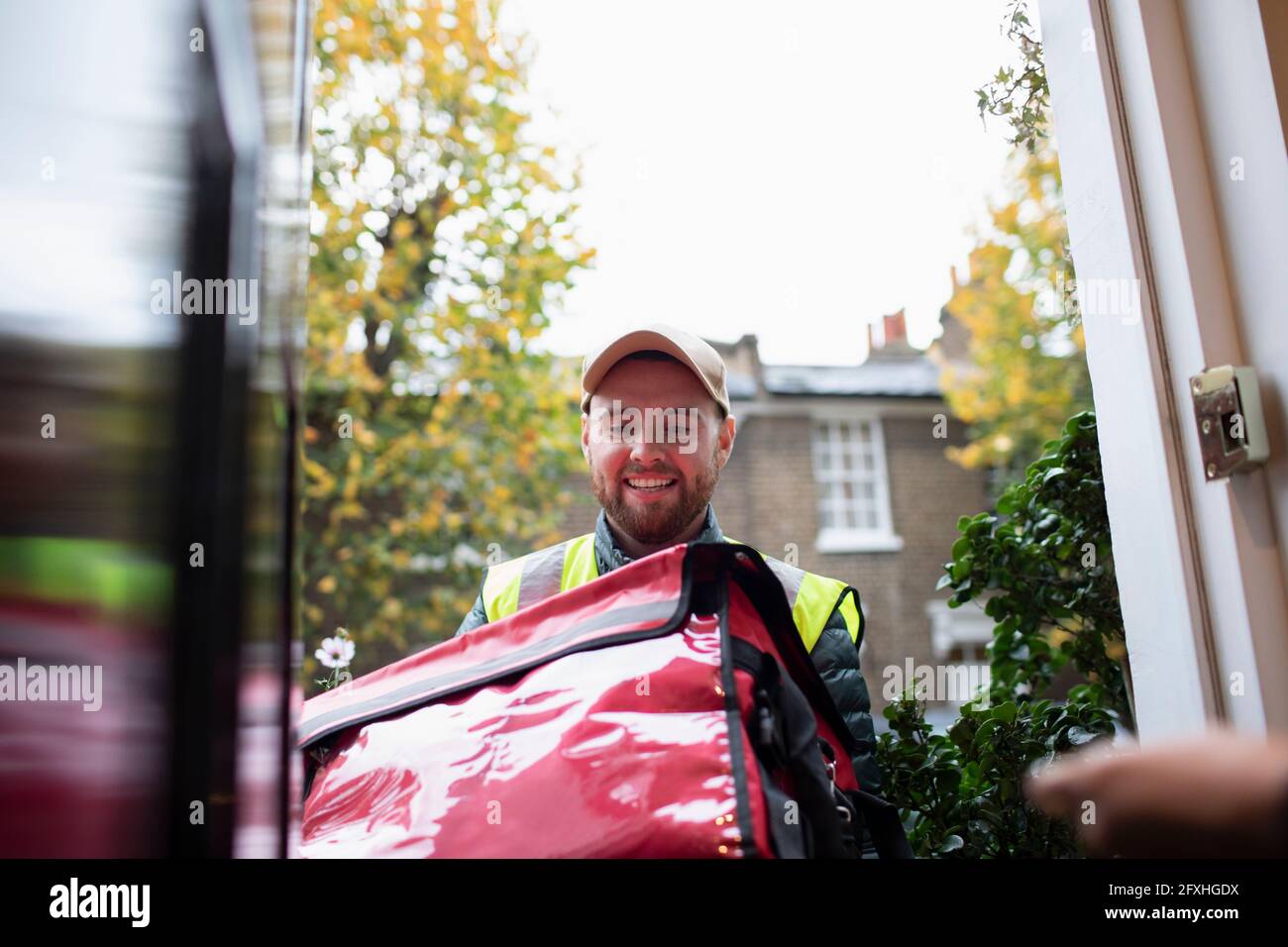 Friendly delivery man delivering food at front door Stock Photo