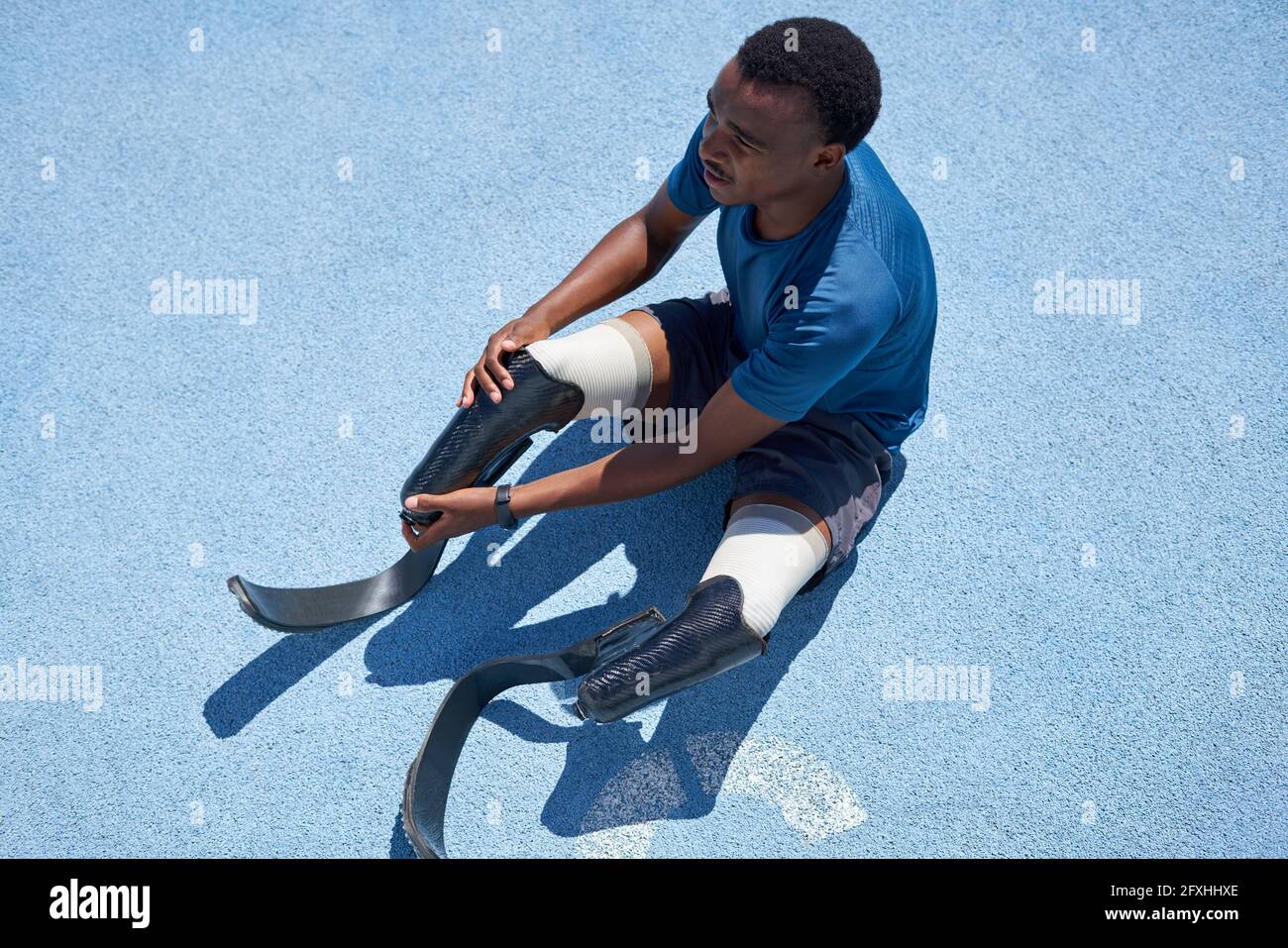 Male amputee sprinter preparing on blue sports track Stock Photo