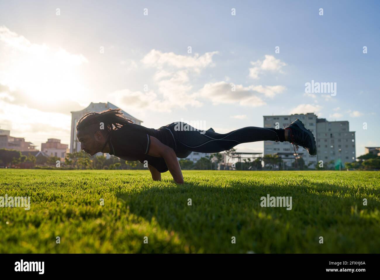 Athletic young man working out in sunny urban park Stock Photo