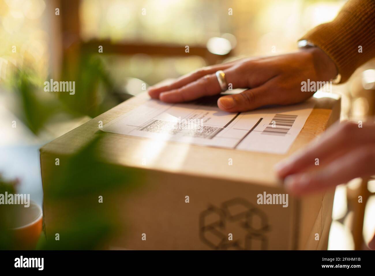 Close up business owner placing shipping label on package Stock Photo